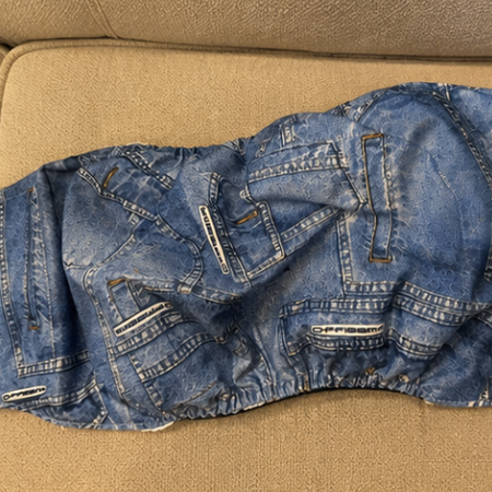 Blue jeans with white patches on a beige couch