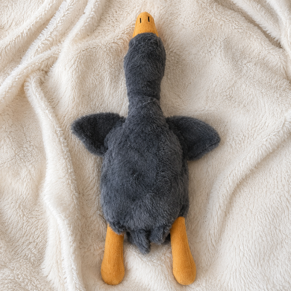 Plush toy resembling a duck on a soft beige surface