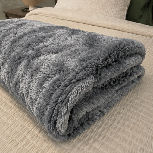 Folded gray blanket on a beige sofa