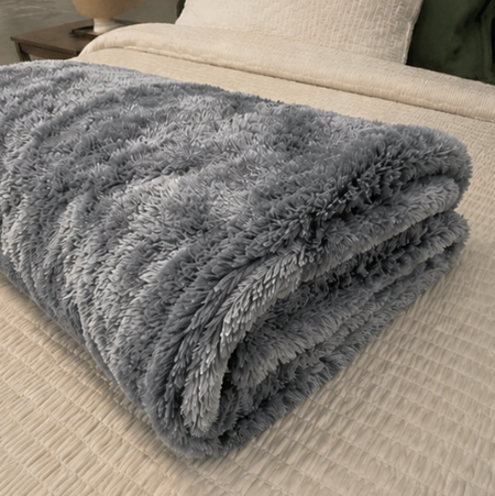Folded gray blanket on a beige sofa