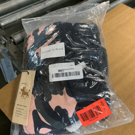 Packaged black gloves with brand labels on a cardboard surface